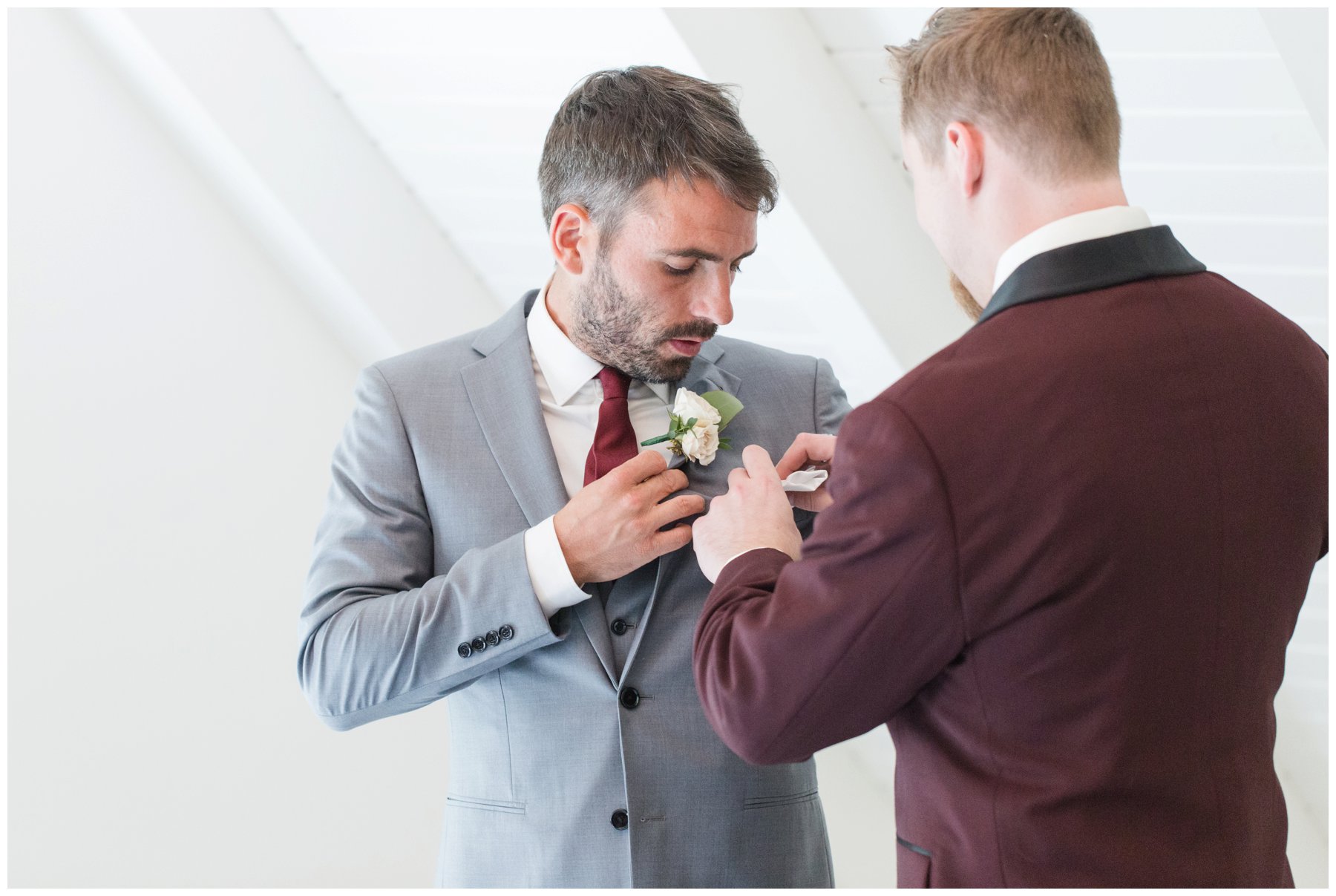 groom putting boutonnière on groomsmen